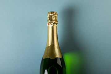Overhead close-up of champagne bottle isolated over blue background, copy space