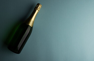 Overhead view of green champagne bottle isolated against blue background, copy space