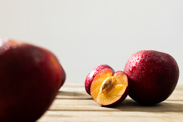 Close-up of fresh wet peaches on wooden table against white background, copy space