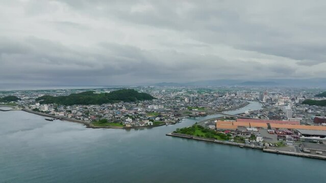Aerial view of river through coastal town to calm coastal waters