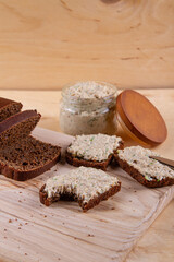 Dark bread with spread on wooden background, adding touch of warmth and charm.