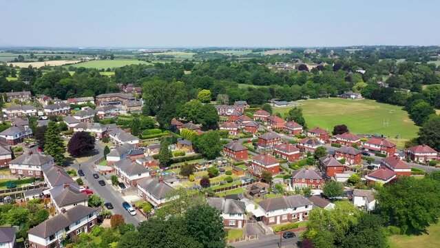 Aerial footage of the beautiful small British town of Hemsworth in the City of Wakefield, West Yorkshire, England showing the housing estates around the town on a hot sunny day in the summer time