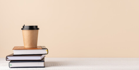Coffee cup on stack of notepads