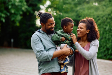 Happy African American parents enjoying with their son outdoors.