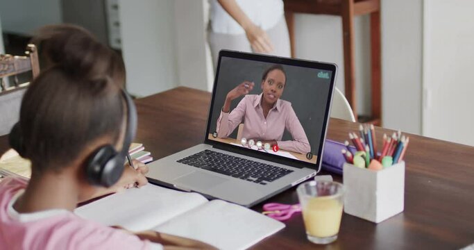 African american girl using laptop for online lesson with african american female teacher on screen