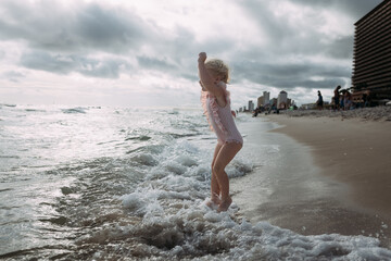 Child jumping in waves on beach on East Coast