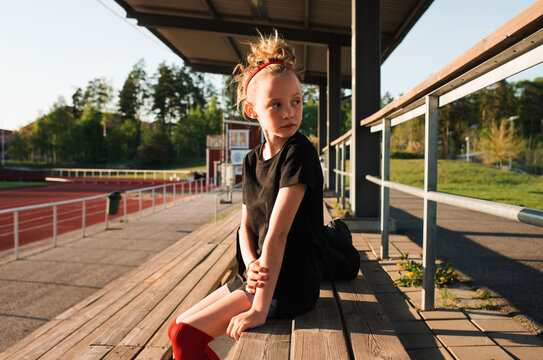 girl sat waiting by the pitch to play football