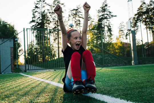 girl cheering for her team mates whilst playing football - Powered by Adobe