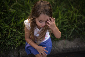 Little girl thinking with hand on forehead