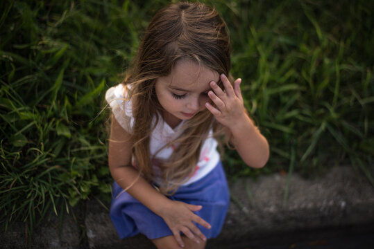 Little girl thinking with hand on forehead