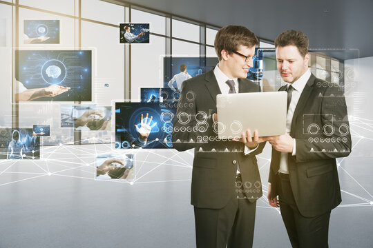 Connecting businesspeople, video conference concept. Attractive european businessmen using laptop with polygonal mesh and images on blurry office interior background.