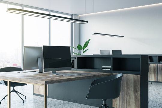 Perspective view of an open office interior with desks, computers, a concrete floor, and white walls. A window lets in natural light. Modern workspace design and business background. 3D Rendering