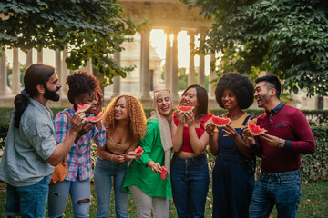 Cheerful group eating watermelon in city