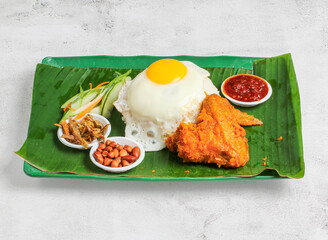 nasi lemak set with sunny egg, rice, chicken wing, pickle, salad, peanut and chilli sauce served in...