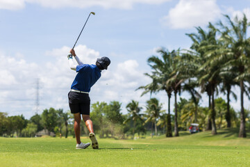 Golfer he's golfing in sunlight. View from the back. Backswing on teeing ground.