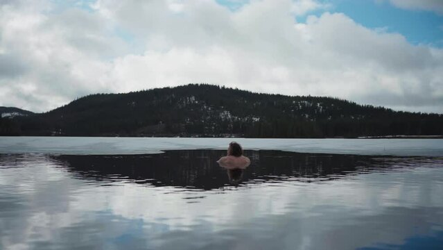 Back View Of A Man Swimming In Freezing Cold Lake In Winter. wide, timelapse