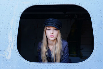 Portrait of a young stewardess in an old plane window