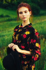 portrait of a beautiful girl with brown hair among the flowers in the field. summer holiday with flowers. countryside