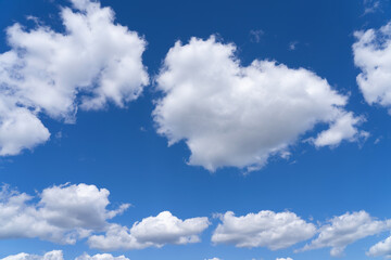 Obraz na płótnie Canvas white fluffy clouds standing out against a black background and a blue sky