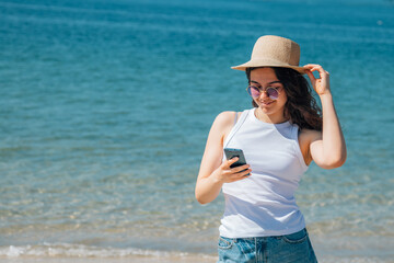 happy girl chatting with mobile phone on the beach