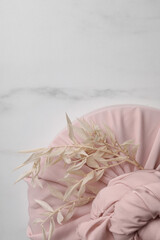 Furoshiki technique. Gift packed in pink fabric and dried branches on white marble table, top view. Space for text
