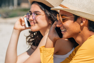 happy young people on the beach talking with mobile phone