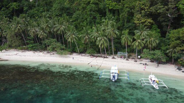 Package Tour Boats arriving Pasandigan Cove Palm Beach on Cadlao Island, El Nido for a lunch Stop. Aerial
