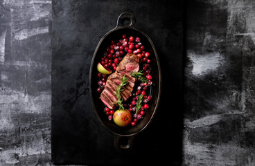 Fototapeta na wymiar Steak on pan. Steak with rosemary. Meat on iron top view.