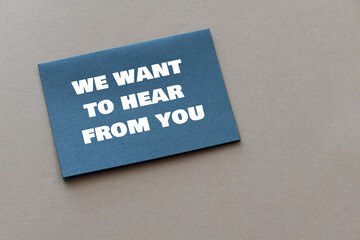 BUSINESS CONCEPT - We want to hear from you text on a black piece of paper.