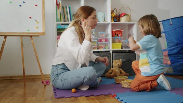 A compassionate therapist guides a child towards confident speech and language skills, blending fun and education in private tutoring sessions tailored to the child's needs