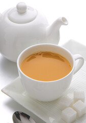 cup of tea with teapot and sugar cubes