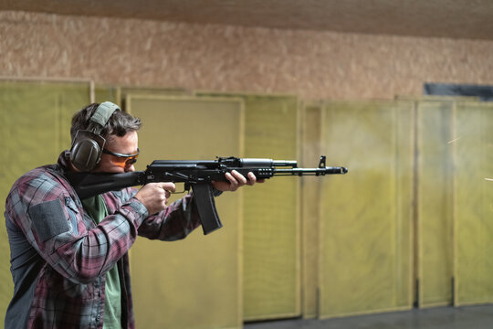 A man shoots from ak 74m in a shooting range, shooting from a rifle at a target.