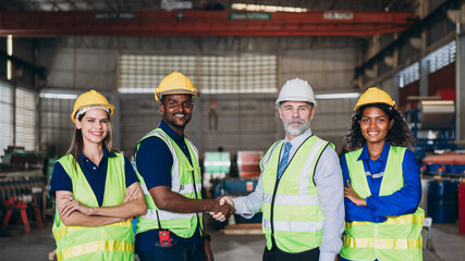 Team engineers and foreman stack hand and shake hands to show success at factory machines. Worker...