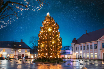 Kuressaare, Estonia - December 17, 2016: Christmas Tree In Evening Night Christmas Xmas Festive Illuminations. Christmas Tree Under Amazing Bold Bright Blue Starry Sky Gradient. Travel To Estonia.