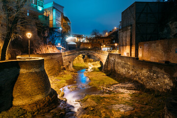 Tbilisi, Georgia, Night Scenic View Of Bridge of Love in Bath District - Is The Ancient District Of Tbilisi, Georgia. Hanging houses above rvier in canyon. Leghvtakhevi Canyon - obrazy, fototapety, plakaty
