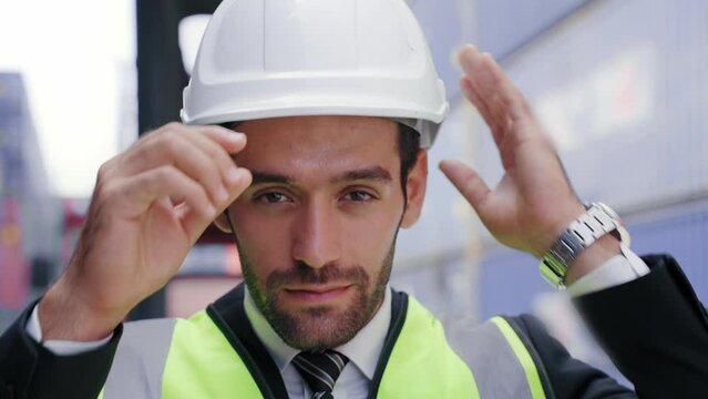 Portrait Close up of Supervisor engineer or Businessman wear vest and helmet safety standing and smiling look at camera at port yard in warehouse area. Logistics and shipping concept