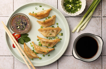 Delicious gyoza (asian dumplings) served on light tiled table, flat lay