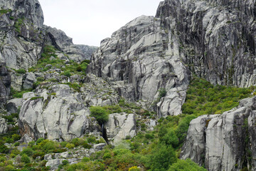 Landscape with rocky cliffs covered by green bushes of Serra da Estrela, Portugal

