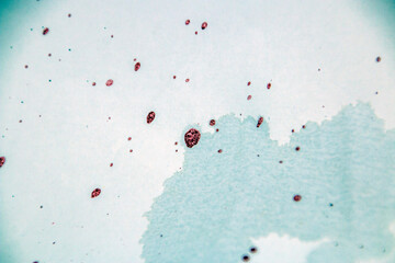 Red and black paint splashes on a white sheet