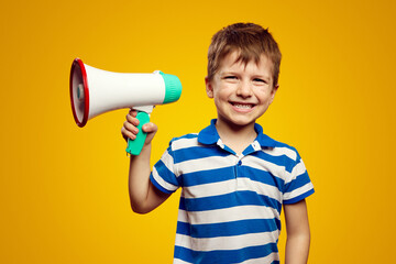 Little small boy wearing blue striped shirt, scream in megaphone announces discounts sale Hurry up isolated on yellow background studio