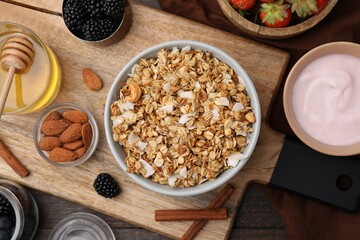 Tasty granola, yogurt and fresh berries served on wooden table, flat lay. Healthy breakfast