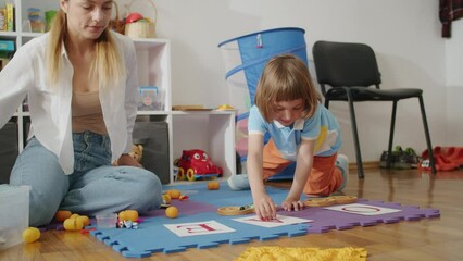 With the guidance of a caring teacher, a child finds happiness in overcoming speech challenges, supported by a female therapist in private tutoring sessions at home