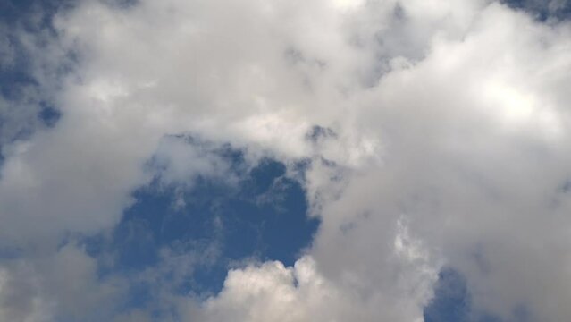 Abstract whitish and grayish clouds moving across the blue sky