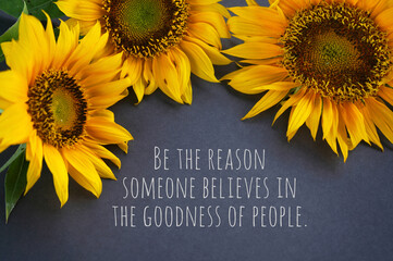 Inspirational quote - Be the reason someone believe in the goodness of people. With three sunflowers on gray background. Kindness concept with yellow flowers floral backgrounds.
