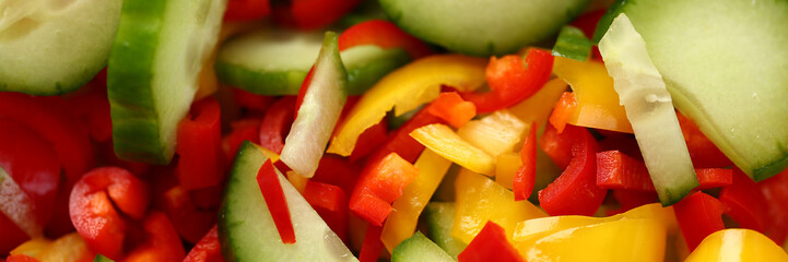 Fresh vegetables cucumbers red yellow peppers sliced in salad. Benefits of vegetarian food concept