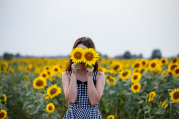 Woman in a field of sunflowers. Sunflowers and emotions. Girl in the field. 