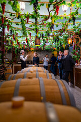 Fototapeta na wymiar Group of Professional sommelier tasting and smelling red wine in wine glass at wine cellar with wooden barrel in wine factory. Winery liquor manufacturing industry and winemaker business concept.