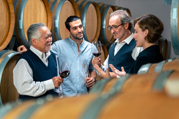 Professional male sommelier explaining and recommending wine to customer and visitors at wine...