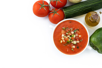 Traditional Spanish gazpacho soup in bowl with ingredients isolated on white background. Top view. Copy space