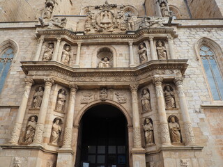 Fototapeta na wymiar fachada principal de la iglesia románica de santa maría la mayor de montblanch con los doce apóstoles, estilo barroco, columnas corintias, virgen maría custodiada por dos ángeles, escultura de dios 